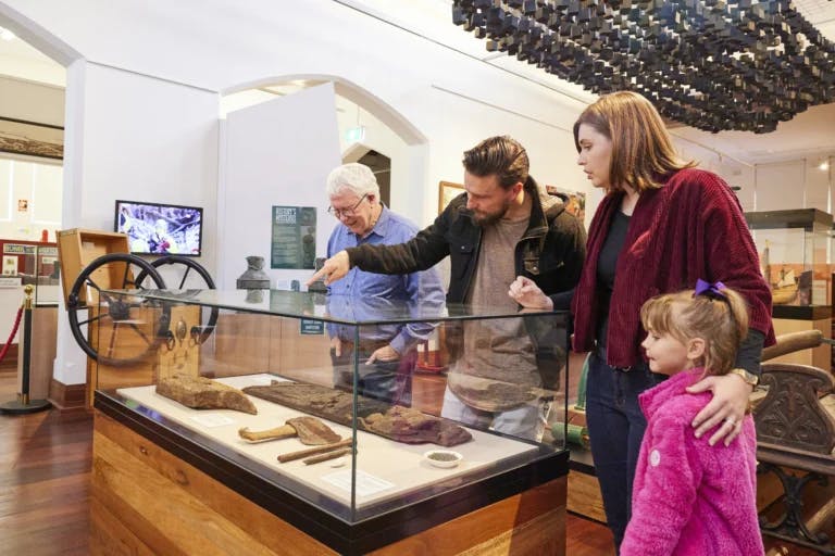 Family inspecting old relics in glass display